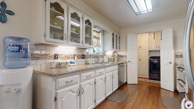 6010 Shadyside Ln, Texarkana, TX 75503 - kitchen with a sink, stainless steel dishwasher, decorative backsplash, glass insert cabinets, and white cabinetry