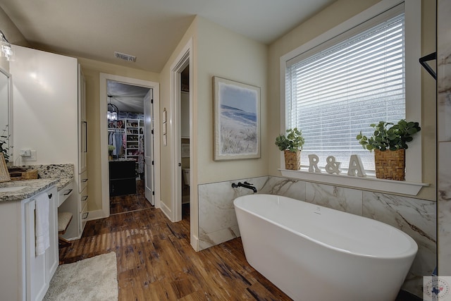 bathroom with vanity, hardwood / wood-style floors, and a tub