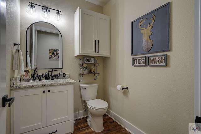 bathroom with wood-type flooring, toilet, and vanity