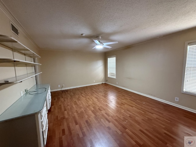 interior space featuring ornamental molding, hardwood / wood-style floors, and a textured ceiling