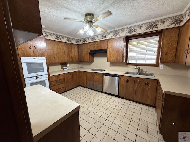 kitchen featuring sink, dishwasher, double oven, and a textured ceiling