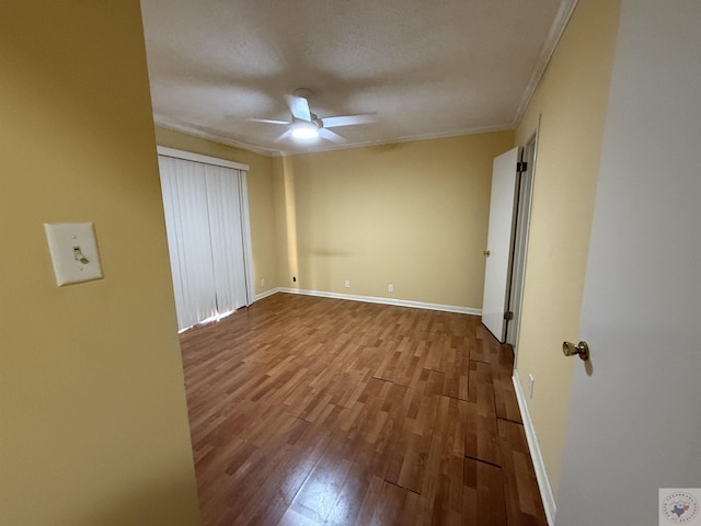 unfurnished bedroom featuring ceiling fan, ornamental molding, and light wood-type flooring