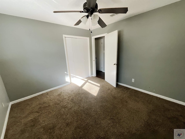 unfurnished bedroom with dark carpet, a closet, and ceiling fan