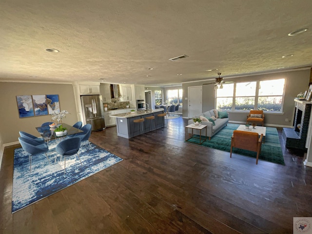 living room featuring a textured ceiling, dark hardwood / wood-style flooring, and a fireplace