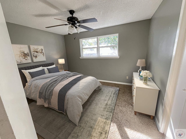 carpeted bedroom featuring ceiling fan and a textured ceiling