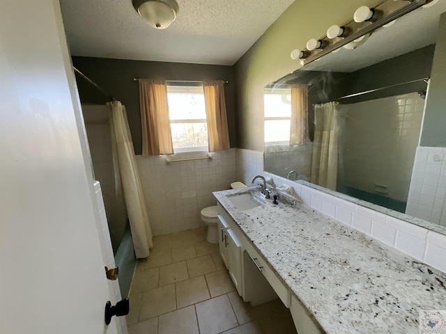 full bathroom featuring a textured ceiling, tile patterned floors, vanity, tile walls, and toilet