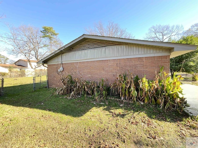 view of side of home with a yard