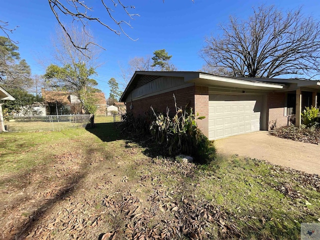 view of side of home featuring a garage and a yard