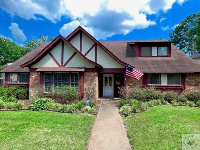 tudor-style house featuring a front yard