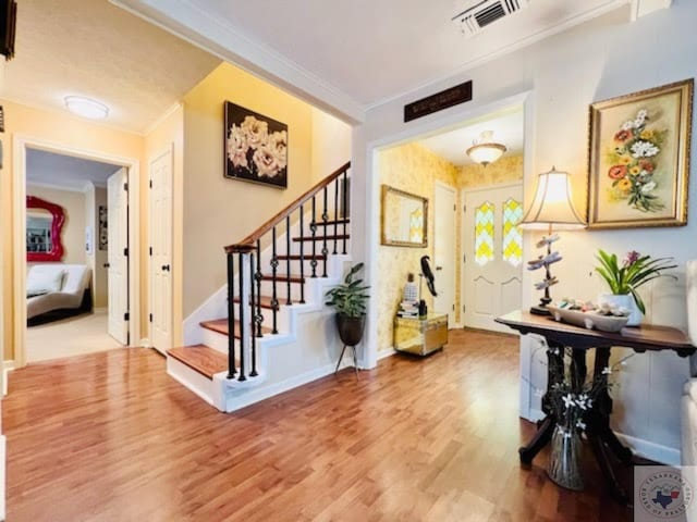 foyer with hardwood / wood-style flooring and ornamental molding