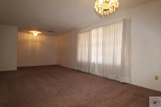 empty room featuring an inviting chandelier and carpet flooring