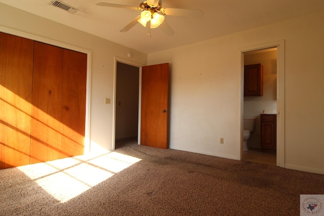 unfurnished bedroom with carpet floors, a closet, ensuite bath, and ceiling fan