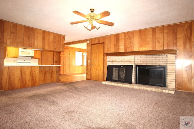 unfurnished living room featuring a brick fireplace, carpet, and wooden walls