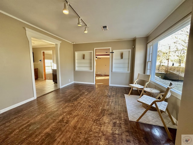 living area with ornamental molding, dark hardwood / wood-style flooring, and rail lighting