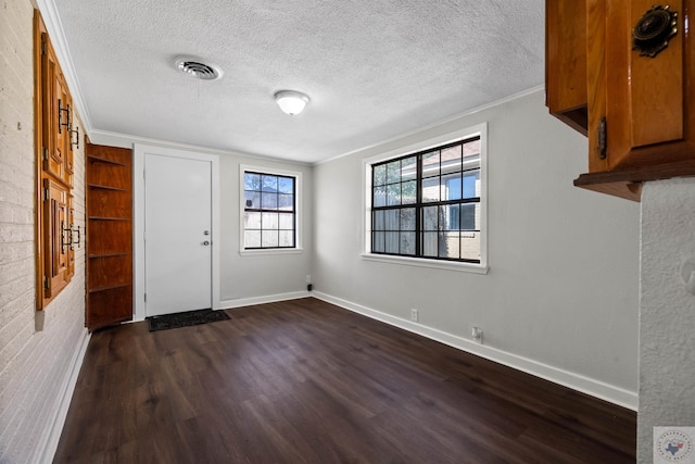 foyer entrance featuring crown molding, dark wood-type flooring, and a textured ceiling