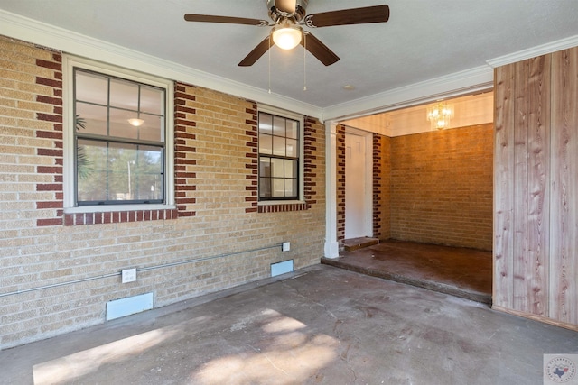 spare room featuring concrete floors, brick wall, and ornamental molding