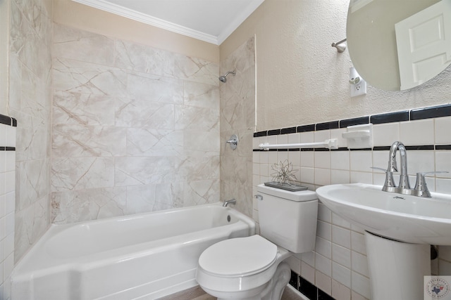 full bathroom with tiled shower / bath combo, sink, tile walls, toilet, and crown molding