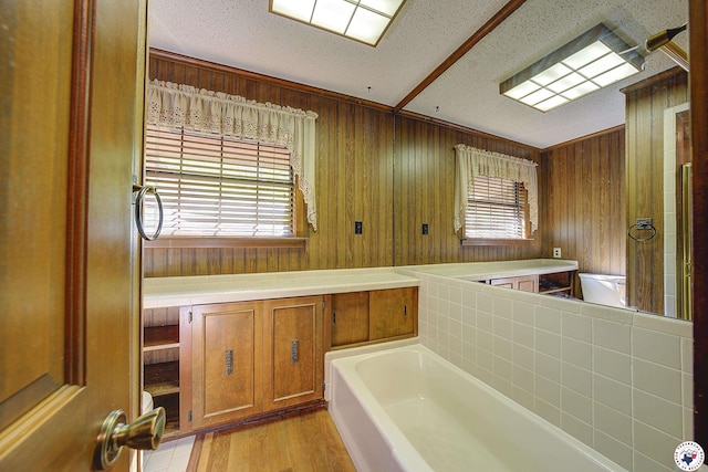full bathroom featuring a textured ceiling, wood finished floors, wood walls, and a washtub