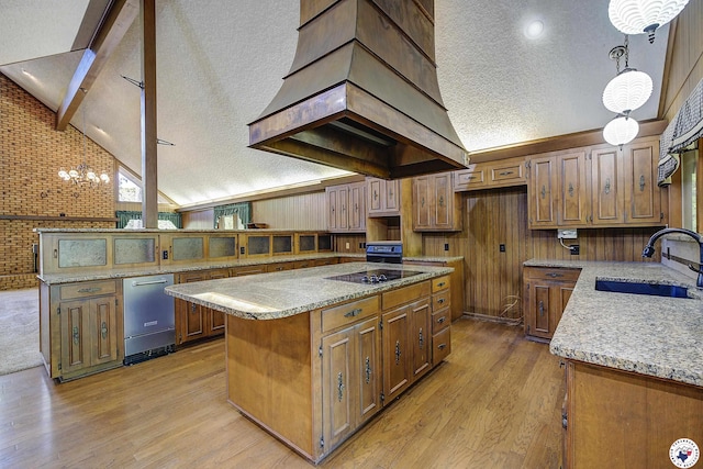kitchen with light wood-style flooring, premium range hood, a textured ceiling, high vaulted ceiling, and a sink