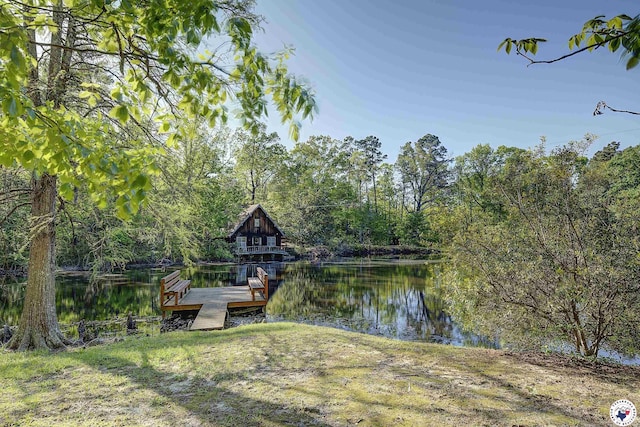 view of dock featuring a forest view and a water view