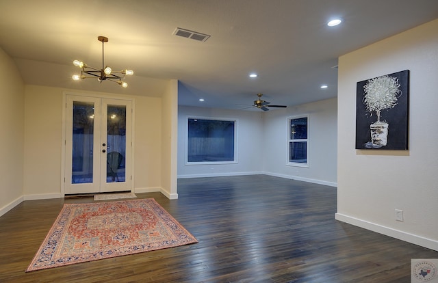 interior space with dark wood-type flooring, ceiling fan with notable chandelier, and french doors