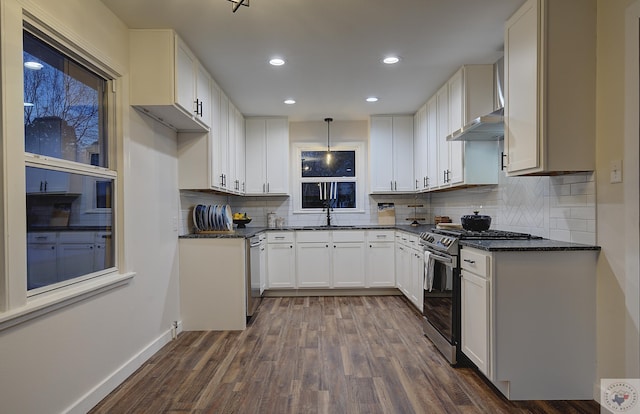 kitchen featuring sink, white cabinetry, decorative light fixtures, dark hardwood / wood-style flooring, and stainless steel appliances