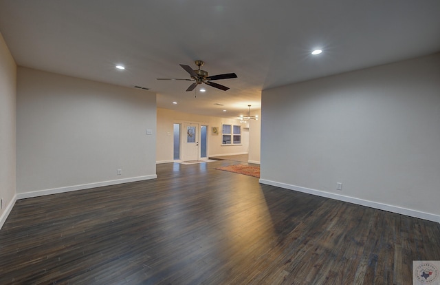 unfurnished living room with dark hardwood / wood-style flooring and ceiling fan with notable chandelier