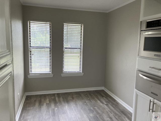 spare room featuring dark hardwood / wood-style flooring and ornamental molding