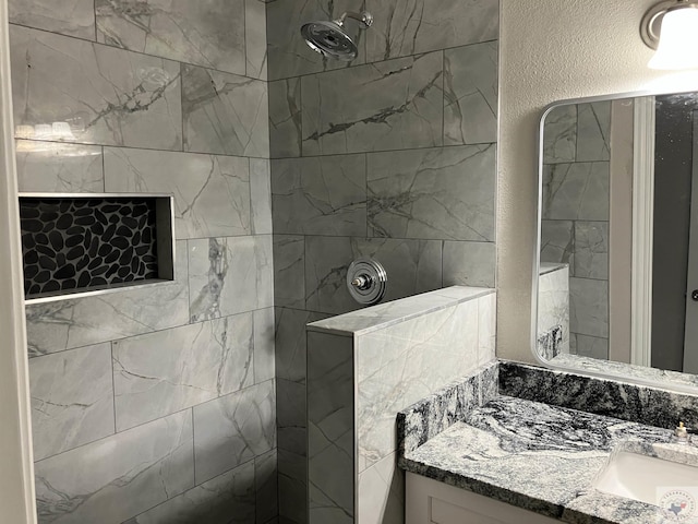 bathroom featuring vanity and a tile shower