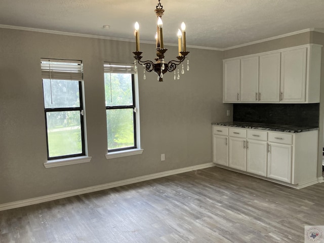 kitchen featuring a chandelier, white cabinetry, light hardwood / wood-style flooring, and tasteful backsplash