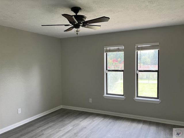 empty room featuring hardwood / wood-style flooring, a textured ceiling, and ceiling fan