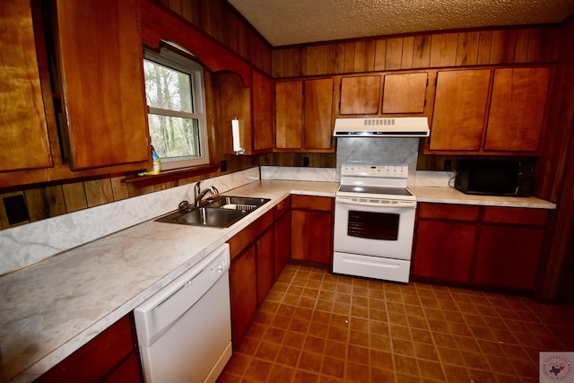 kitchen featuring sink, white appliances, and a textured ceiling