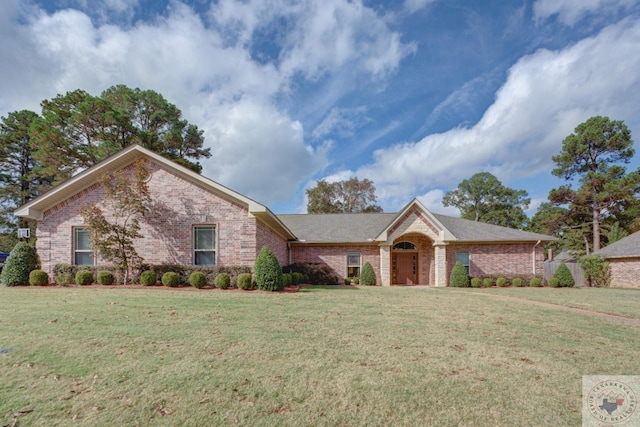 ranch-style house featuring a front yard and brick siding