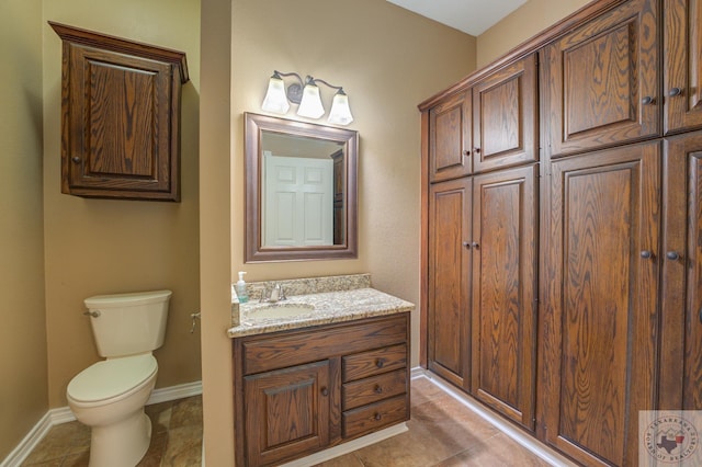 bathroom with vanity, tile patterned floors, toilet, and baseboards