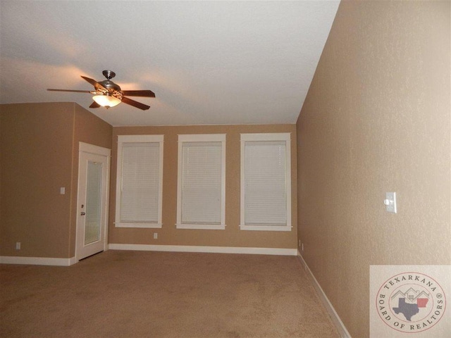 carpeted spare room featuring ceiling fan