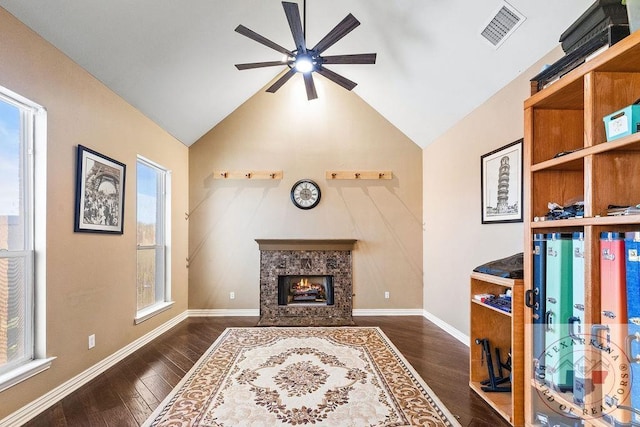 living room with a premium fireplace, a wealth of natural light, dark hardwood / wood-style floors, and lofted ceiling