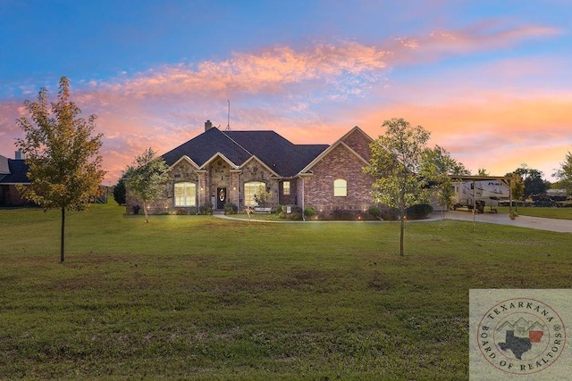 view of front of property featuring a lawn and a carport