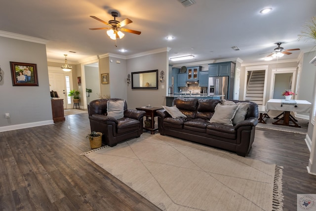 living room featuring wood-type flooring, ceiling fan, and crown molding