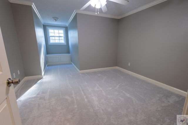 spare room featuring light carpet, ceiling fan, and crown molding