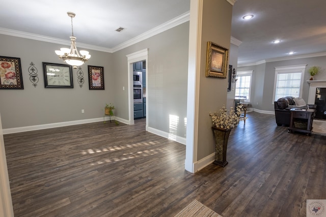 interior space with dark hardwood / wood-style flooring, crown molding, and an inviting chandelier