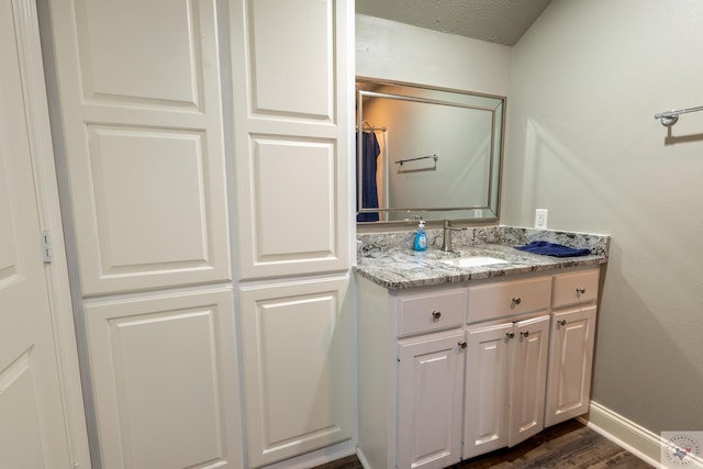 bathroom featuring vanity, a textured ceiling, and wood-type flooring