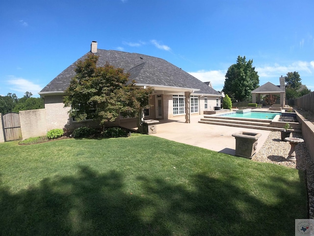 rear view of property with a fenced in pool, a yard, a gazebo, and a patio