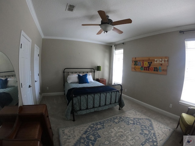 carpeted bedroom with ceiling fan, a textured ceiling, and ornamental molding