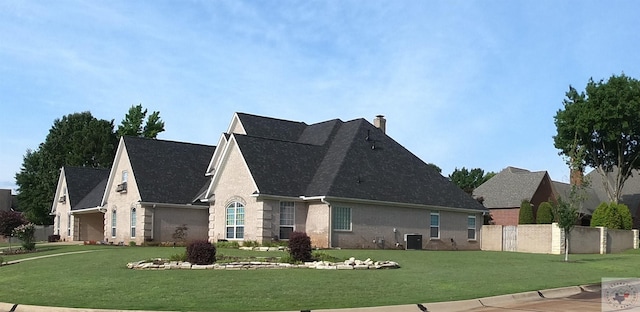 view of side of property with central air condition unit and a lawn