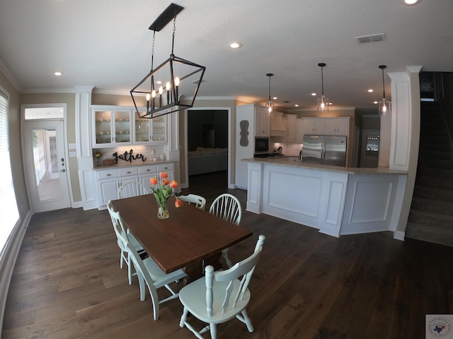 dining room with dark wood-type flooring, a wealth of natural light, and crown molding