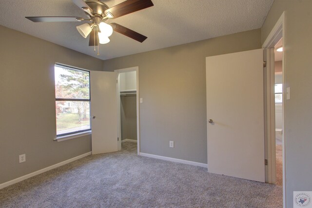 unfurnished bedroom with multiple windows, light colored carpet, a closet, and ceiling fan