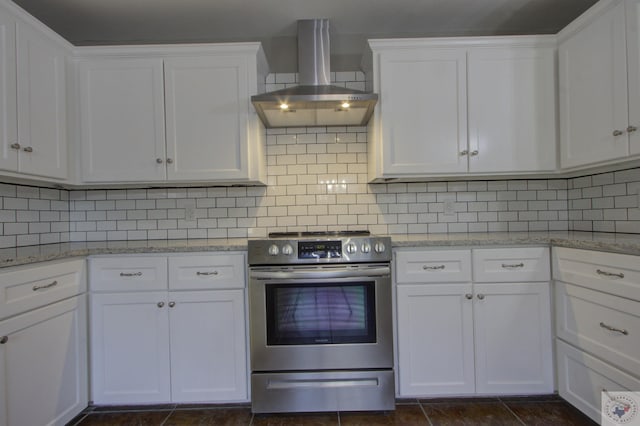 kitchen with white cabinets, wall chimney exhaust hood, stainless steel range, and tasteful backsplash