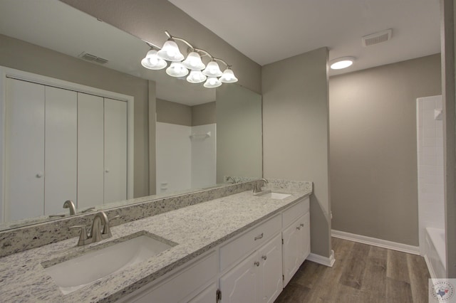 bathroom featuring bathtub / shower combination, hardwood / wood-style floors, and vanity