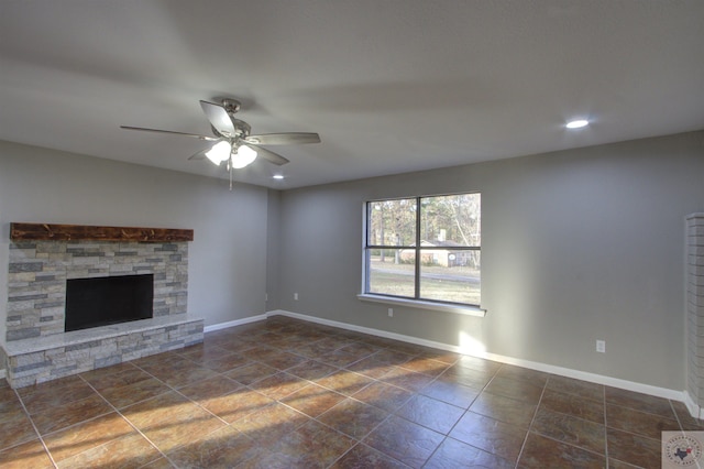 unfurnished living room featuring ceiling fan and a fireplace