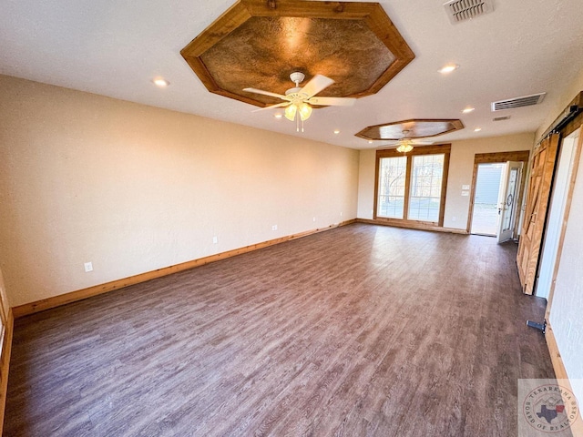 unfurnished living room with ceiling fan, dark hardwood / wood-style flooring, and a raised ceiling